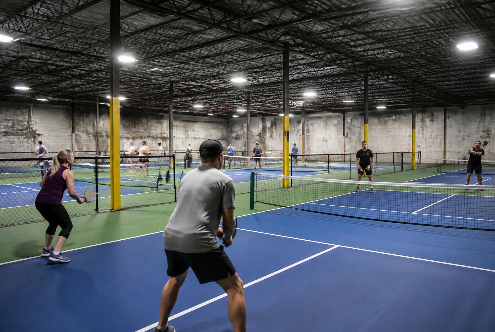 Indoor pickleball facility with busy courts